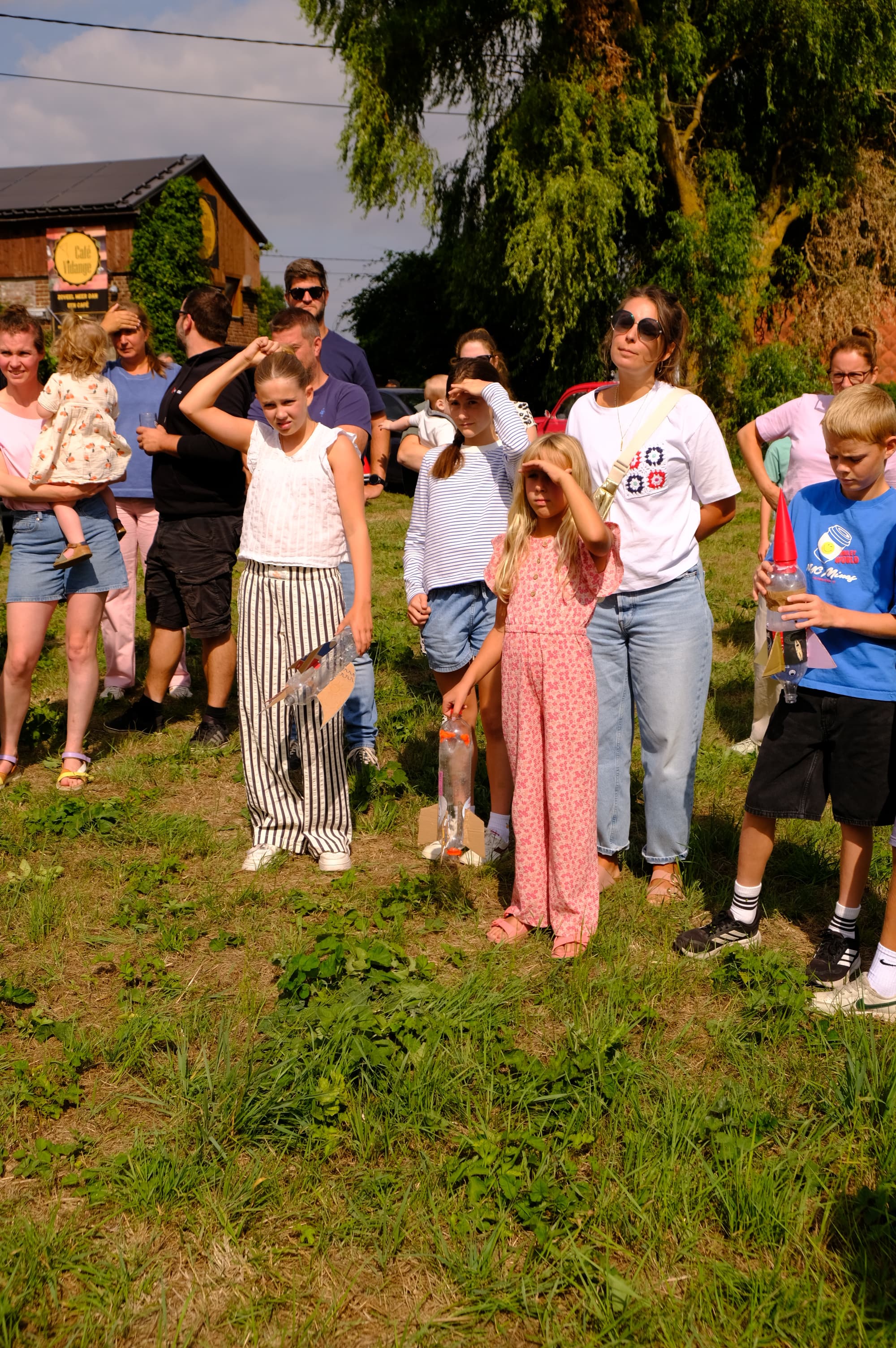 Families gathered on the grass, kids holding their finished water rockets.