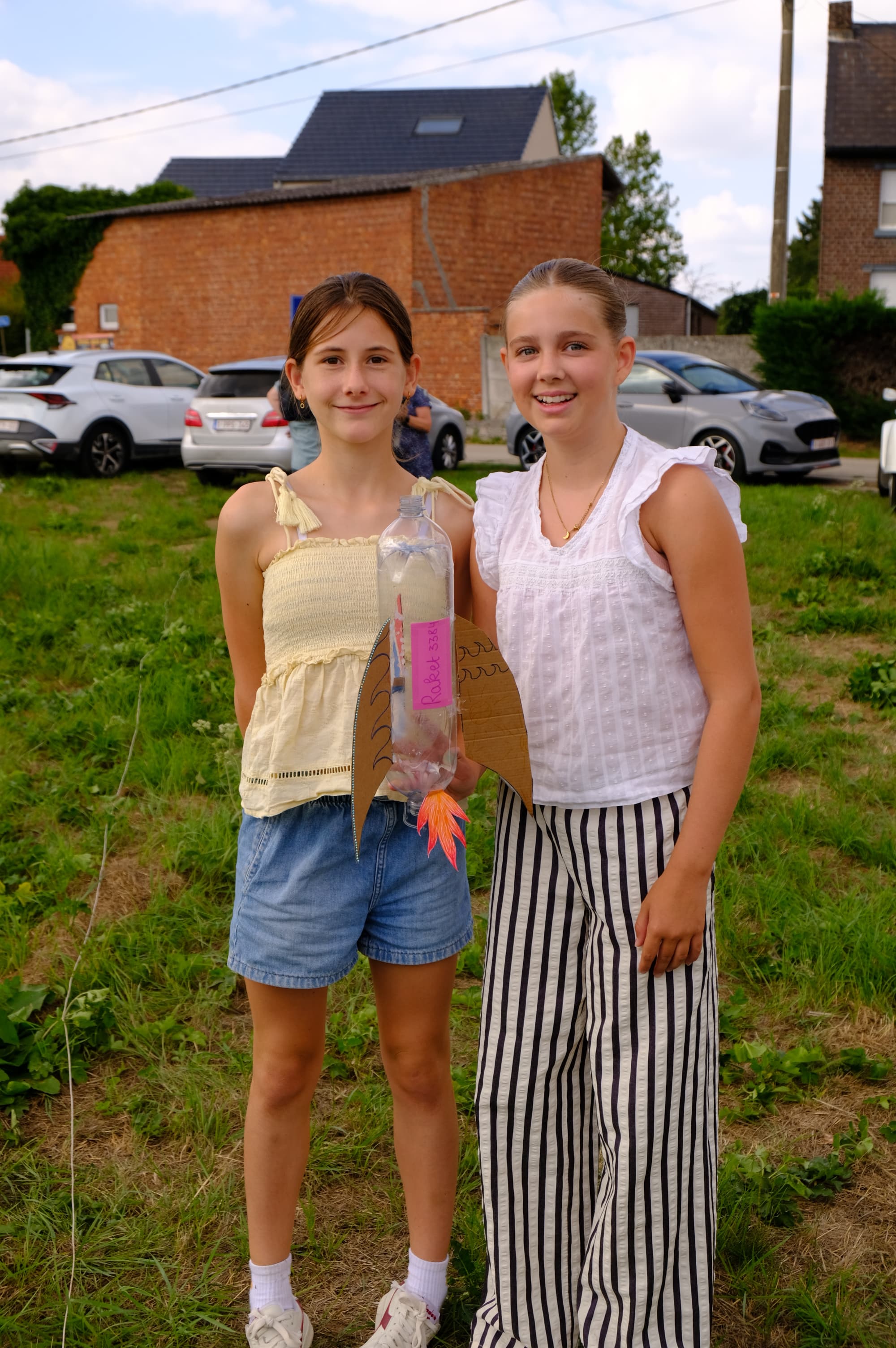 A team member and a young builder with his rocket by the launch stand.