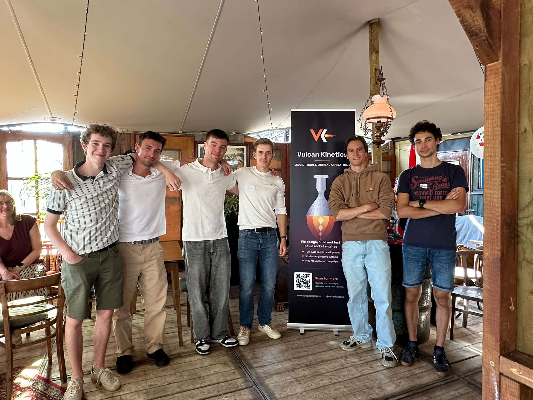 Vulcan Kinetics team members at a recruitment event, standing beside the team banner.